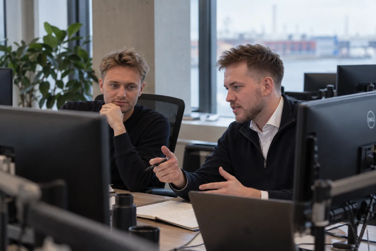 To konsulenter fra Proview arbejder sammen ved skærmene på kontoret